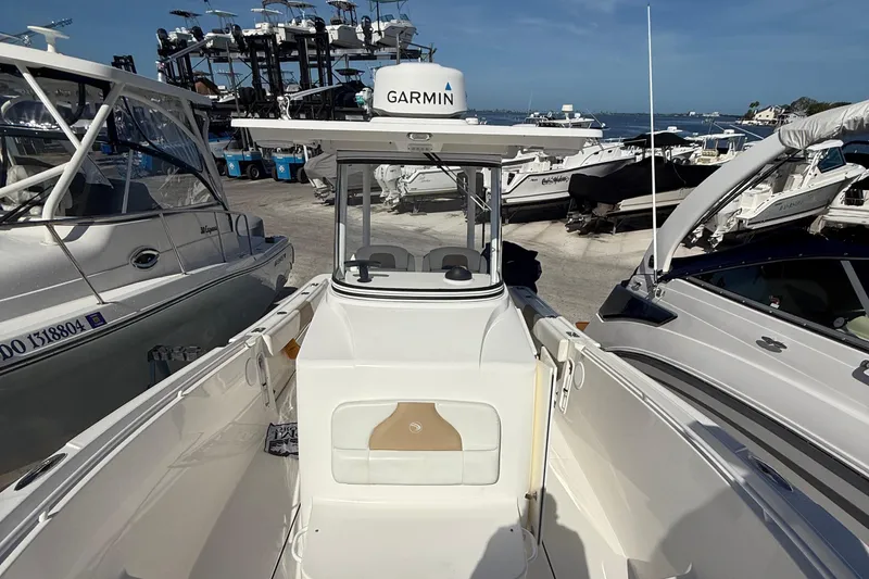 Slide: The Image of 2016 Edgewater 280CC boat docked, featuring Garmin equipment, surrounded by other boats. - 37