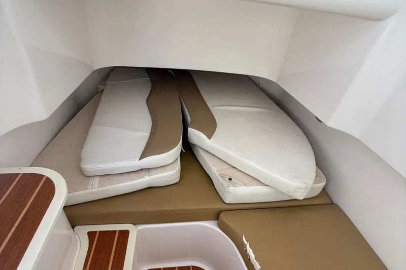 Slide: The Image of 2016 Edgewater 280CC cabin interior with stacked cushions and wooden accents. - 41