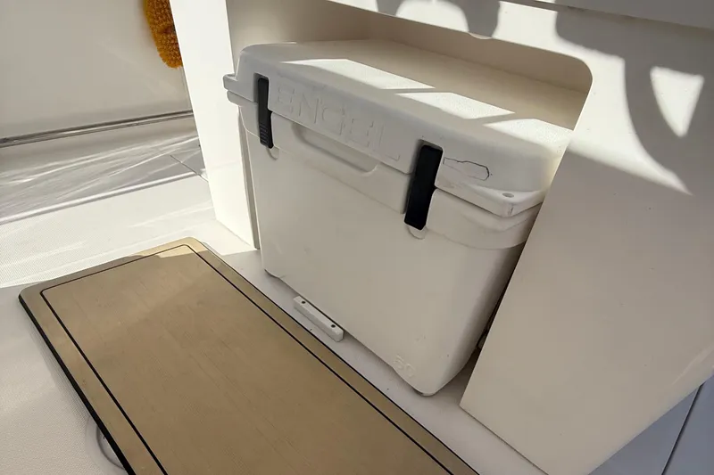 Slide: The Image of White cooler on 2016 Edgewater 280CC boat, secured in a storage compartment. - 43