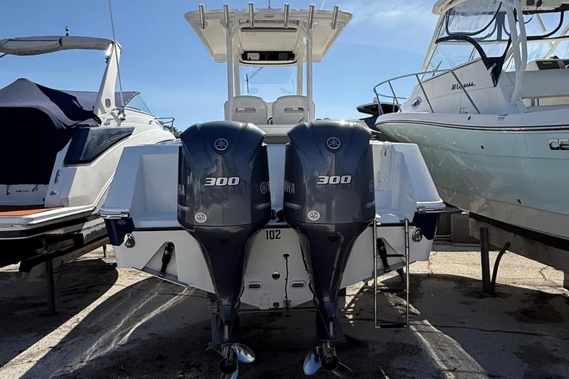 Slide: The Image of 2016 Edgewater 280CC boat with dual Yamaha 300 engines, docked between other boats. - 46
