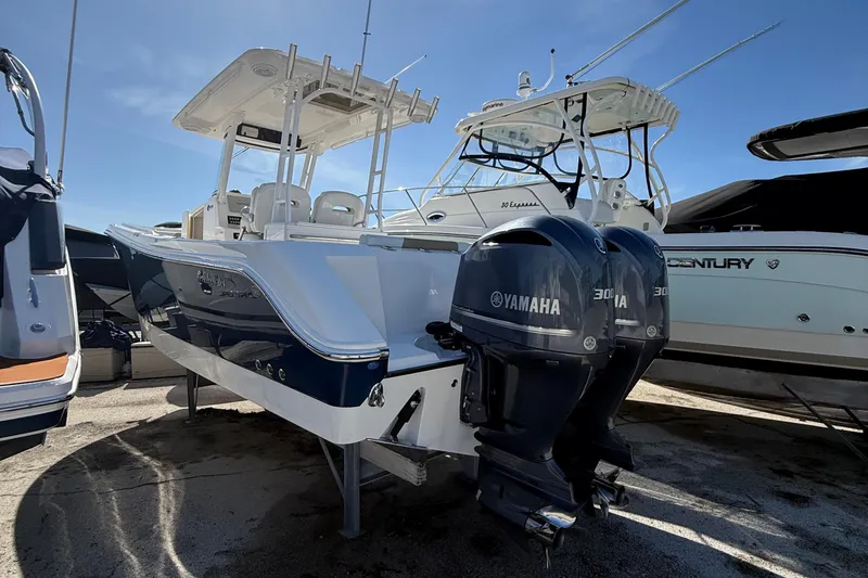 Slide: The Image of 2016 Edgewater 280CC boat with dual Yamaha engines, docked under clear blue sky. - 48