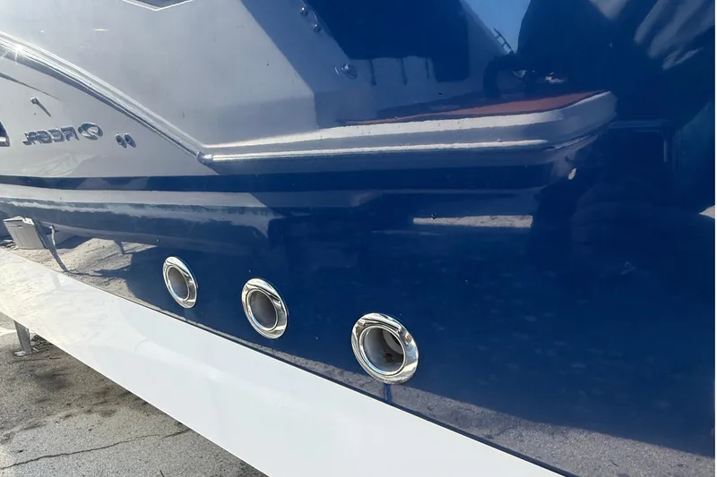 Slide: The Image of 2016 Edgewater 280CC boat hull with chrome fittings and sleek blue finish. - 49