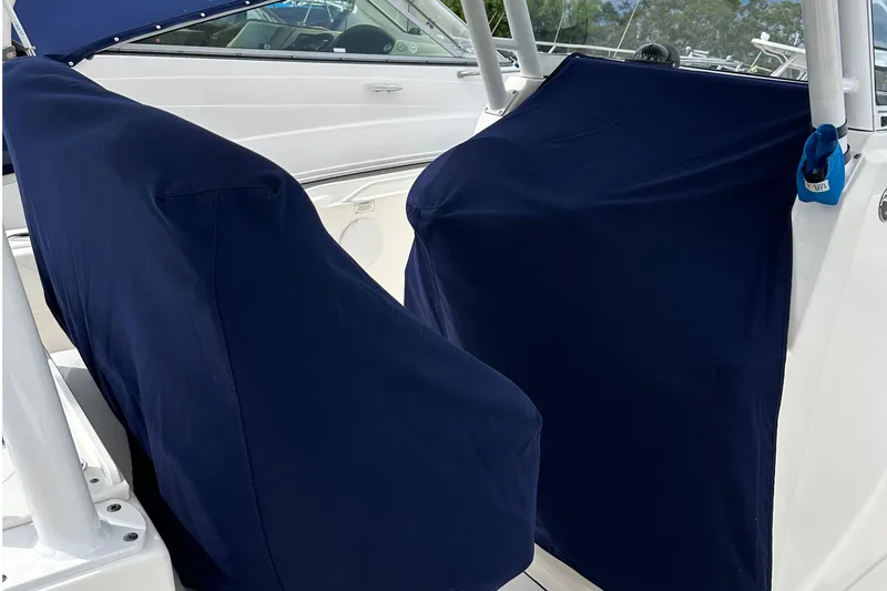 Slide: The Image of Covered seats on a 2016 Edgewater 280CC boat, featuring navy blue fabric. - 54