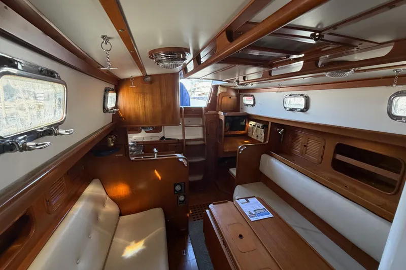 Slide: The Image of Interior of 1985 Mason 33 sailboat with wooden finish and seating area. - 11