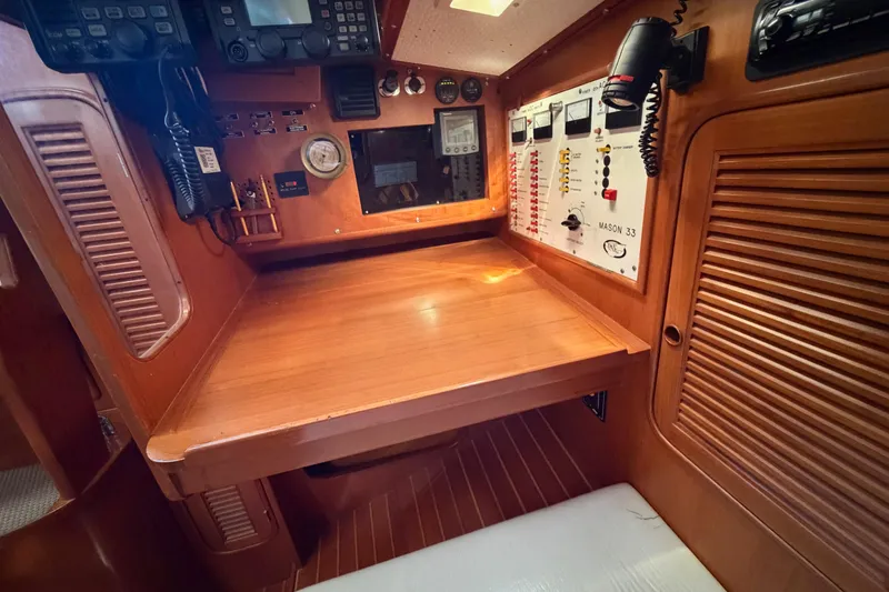 Slide: The Image of Navigation station of 1985 Mason 33 yacht with control panels and communication equipment. - 14