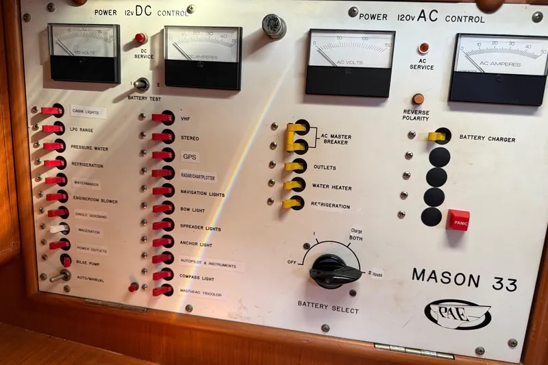 Slide: The Image of Control panel of a 1985 Mason 33 boat with various switches and gauges. - 23