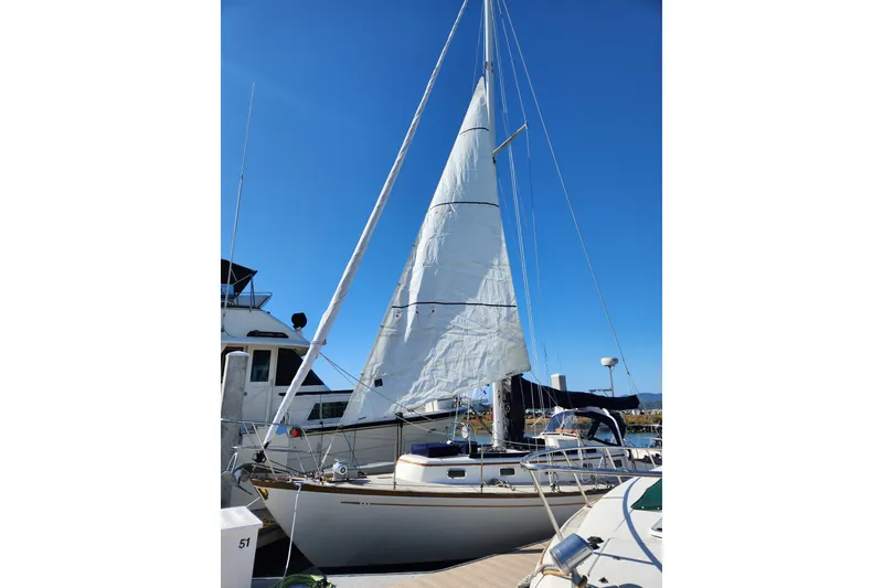 Slide: The Image of Sailboat Mason 33, 1985 model, docked under clear blue sky. - 4