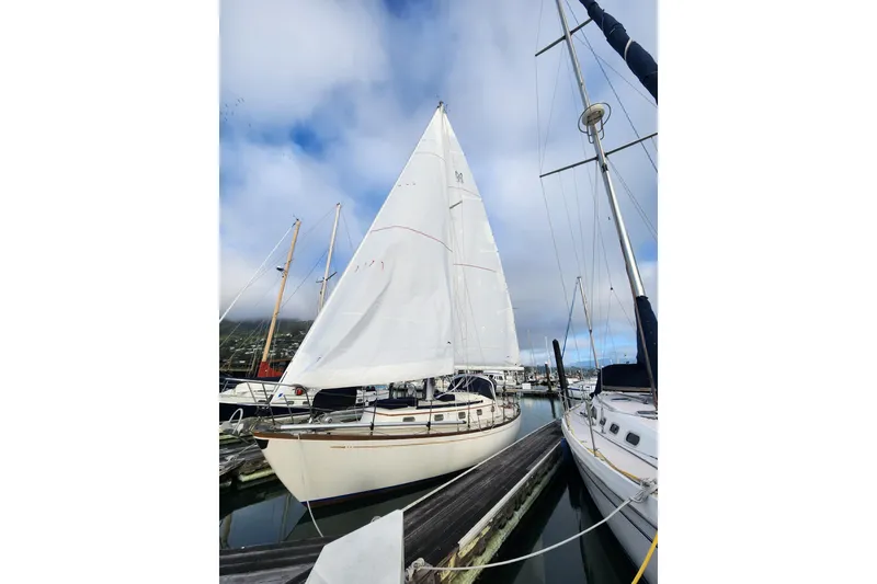 Slide: The Image of 1985 Mason 33 sailboat docked at marina under cloudy sky. - 6