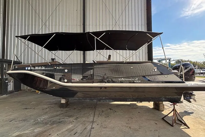 Slide: The Image of 2017 Bayliner Element XR7 boat with canopy in a storage facility. - 1