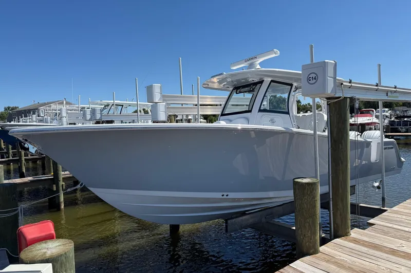 The Image of 2026 Sportsman Open 302 Center Console boat docked at marina under clear blue sky. - 0