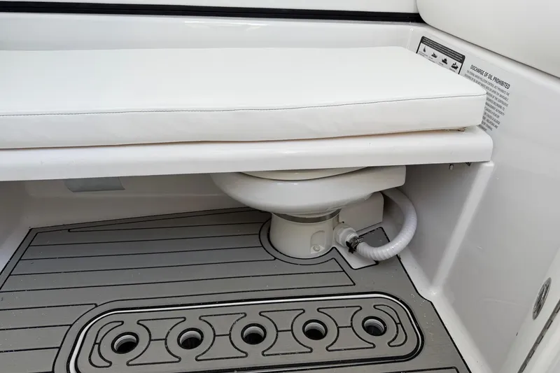 Slide: The Image of 2026 Sportsman Open 302 Center Console boat interior with cushioned seating and marine toilet. - 13