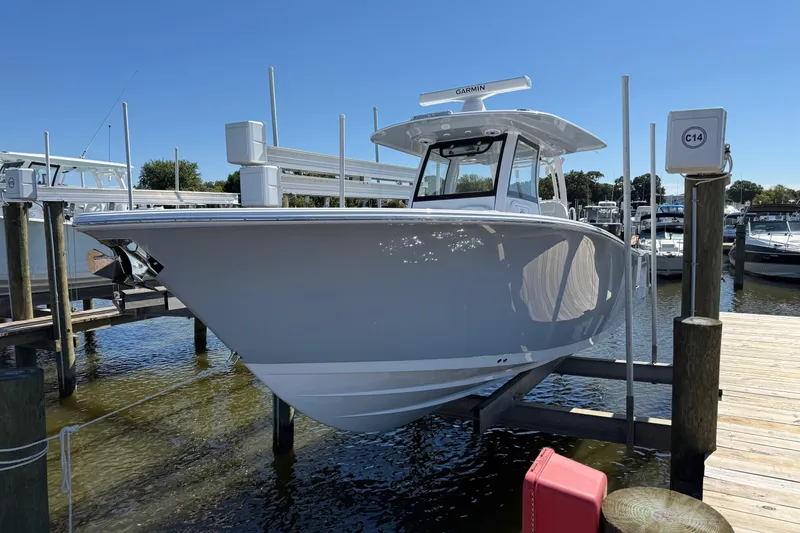 Slide: The Image of 2026 Sportsman Open 302 Center Console boat docked at marina under clear blue sky. - 2