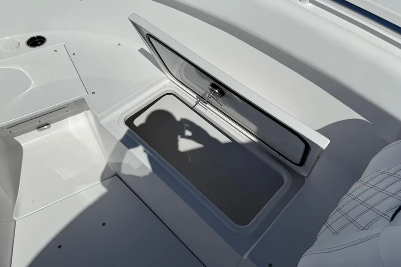 Slide: The Image of 2026 Sportsman Open 302 Center Console boat storage compartment with open lid. - 20
