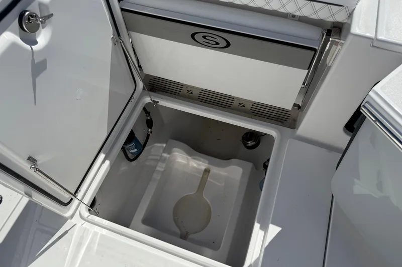Slide: The Image of 2026 Sportsman Open 302 Center Console storage compartment with open hatch and visible equipment. - 6