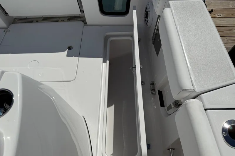 Slide: The Image of 2026 Sportsman Open 302 Center Console boat interior with storage compartment open. - 8