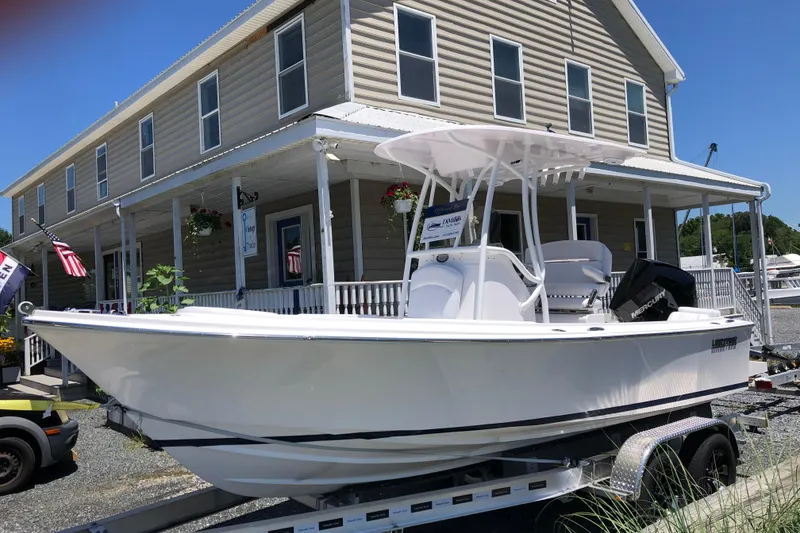 The Image of 2022 Limestone L200CC boat on trailer outside a building with American flags. - 0