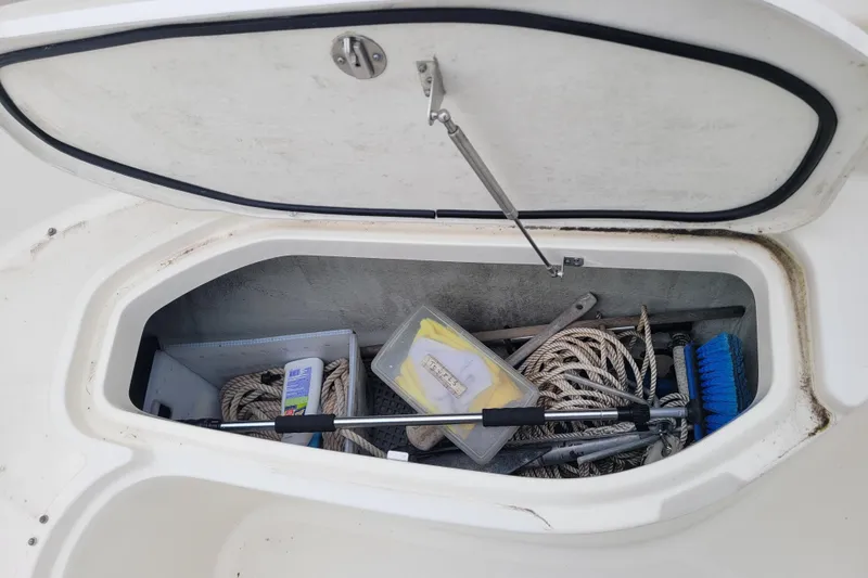 Slide: The Image of Open storage compartment on 2008 Pursuit C 250 Center Console boat with ropes and cleaning supplies. - 18