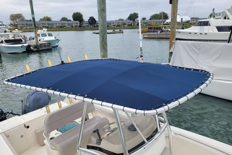 Slide: The Image of 2008 Pursuit C 250 Center Console boat with blue T-top at marina. - 4