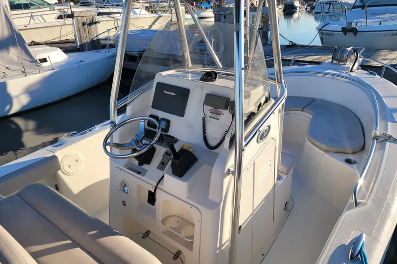 Slide: The Image of 2008 Pursuit C 250 Center Console boat interior at marina, featuring steering and navigation equipment. - 5