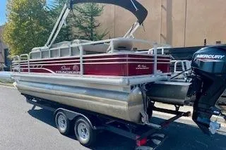 Slide: The Image of 2023 Sun Tracker Fishin' Barge 20 DLX pontoon boat on trailer, featuring Mercury outboard motor. - 3