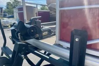 Slide: The Image of 2023 Sun Tracker Fishin' Barge 20 DLX pontoon boat on trailer, close-up view. - 4