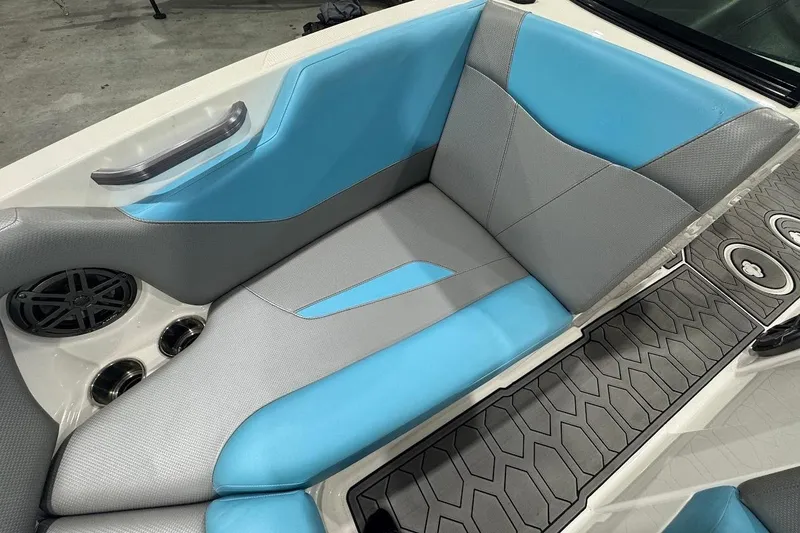 Slide: The Image of 2020 MasterCraft NXT22 interior with blue and gray seating, cup holders, and speaker. - 14