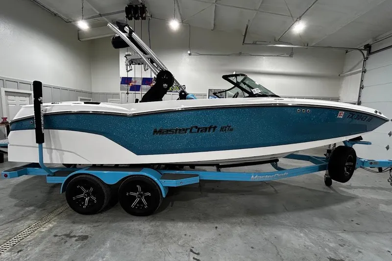 Slide: The Image of 2020 MasterCraft NXT22 boat on trailer in indoor garage setting. - 3