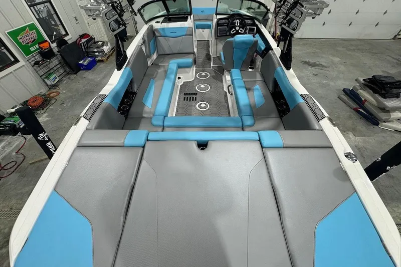 Slide: The Image of 2020 MasterCraft NXT22 boat interior with blue and gray seating in a garage setting. - 4