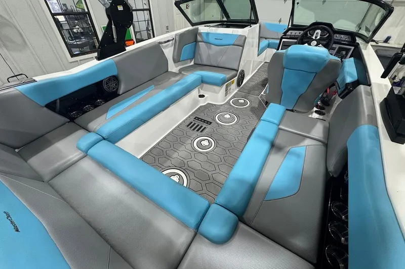 Slide: The Image of 2020 MasterCraft NXT22 boat interior with blue and gray seating, modern dashboard, and hexagonal flooring. - 5