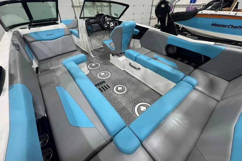 Slide: The Image of 2020 MasterCraft NXT22 boat interior with blue and gray seating, modern dashboard, and spacious layout. - 6