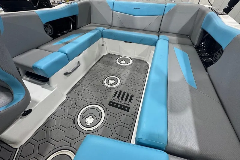 Slide: The Image of 2020 MasterCraft NXT22 boat interior with blue and gray seating and hexagonal floor design. - 7
