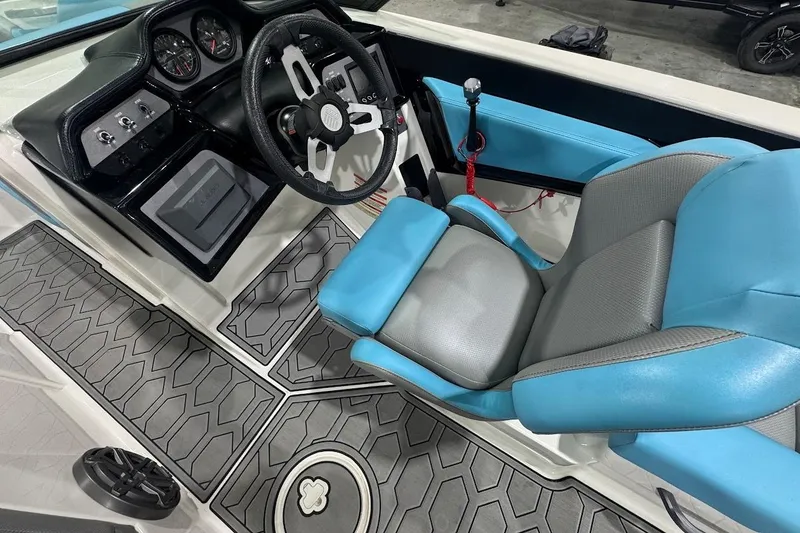 Slide: The Image of 2020 MasterCraft NXT22 boat interior with blue and gray seating, modern dashboard, and textured flooring. - 9