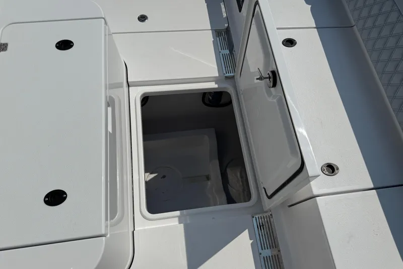 Slide: The Image of 2026 Sportsman Heritage 321 Center Console boat storage compartment open. - 14
