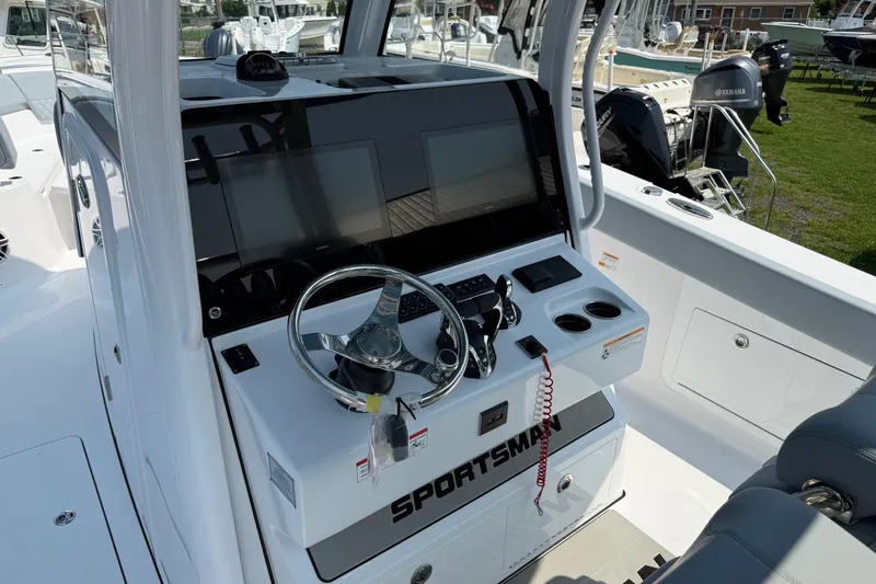 Slide: The Image of 2026 Sportsman Heritage 321 Center Console boat interior with steering wheel and control panel. - 21