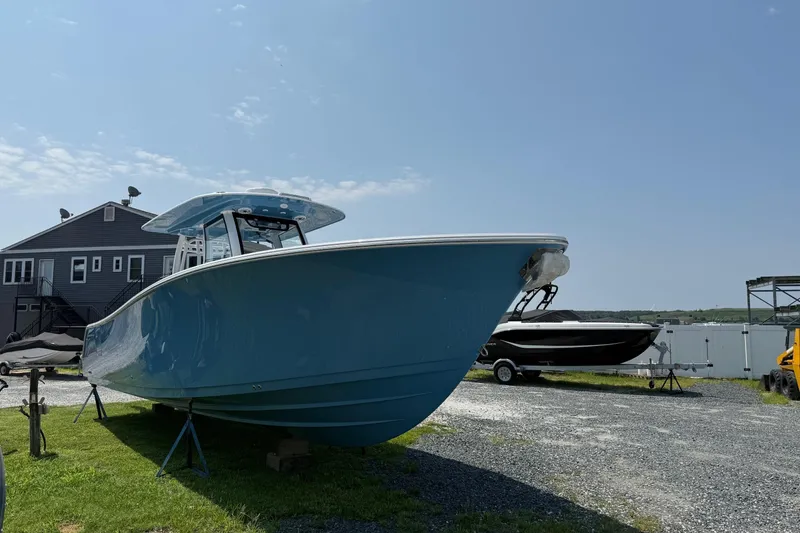 Slide: The Image of 2026 Sportsman Heritage 321 Center Console boat on display outdoors. - 3
