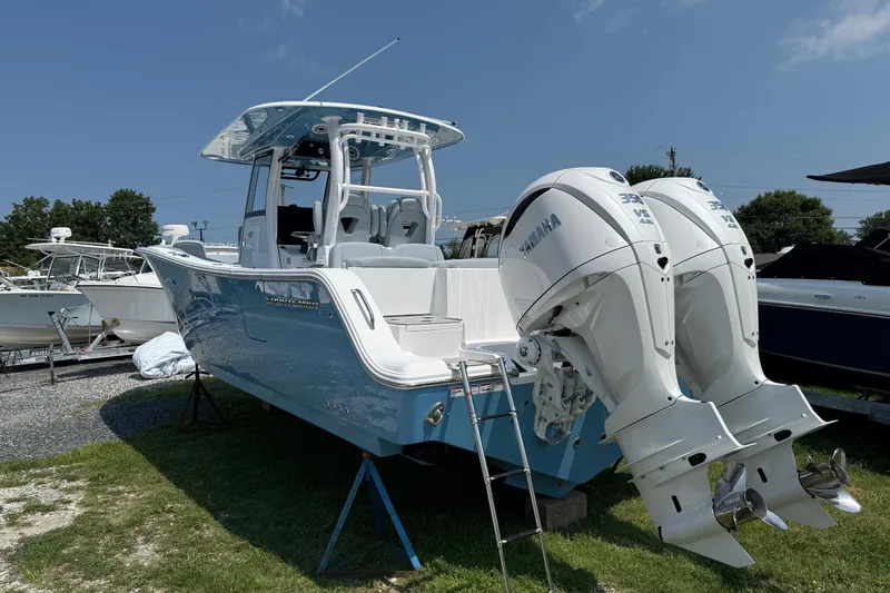 Slide: The Image of 2026 Sportsman Heritage 321 Center Console boat with twin Yamaha engines, displayed outdoors. - 5