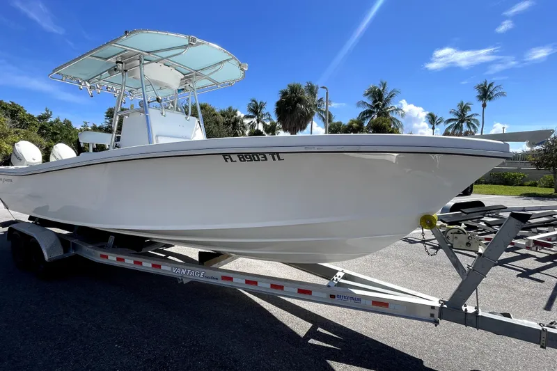 The Image of 2013 Ocean Master 27 Center Console boat on trailer, sunny day, palm trees in background. - 1