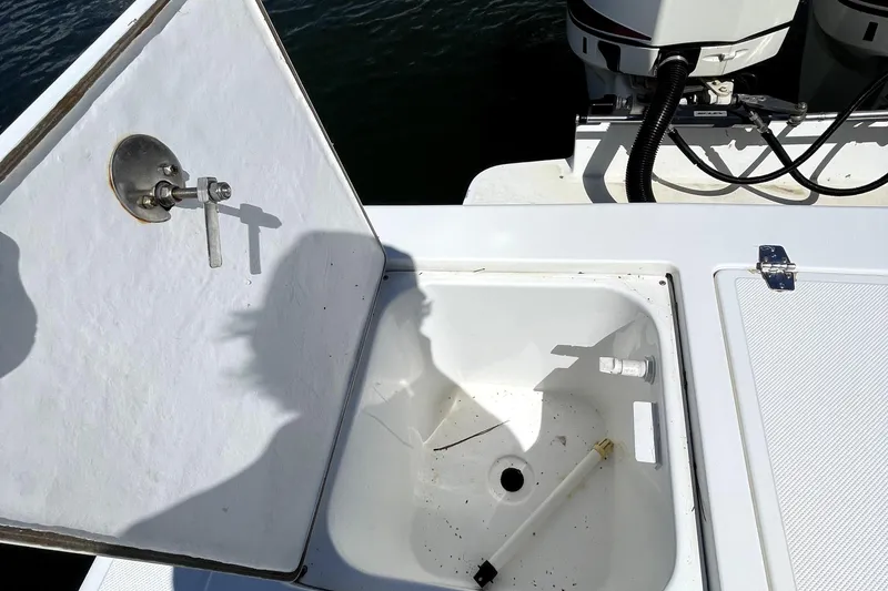 Slide: The Image of Open hatch on 2013 Ocean Master 27 Center Console boat, revealing storage compartment. - 7