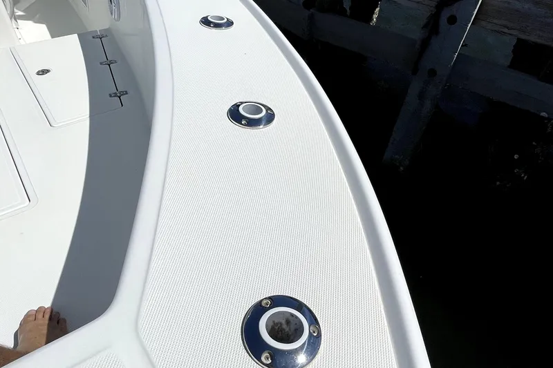 Slide: The Image of 2013 Ocean Master 27 Center Console boat deck with rod holders and textured surface. - 12