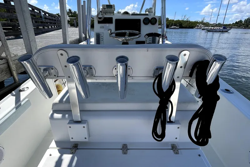 Slide: The Image of 2013 Ocean Master 27 Center Console boat with rod holders and ropes, docked by the water. - 9