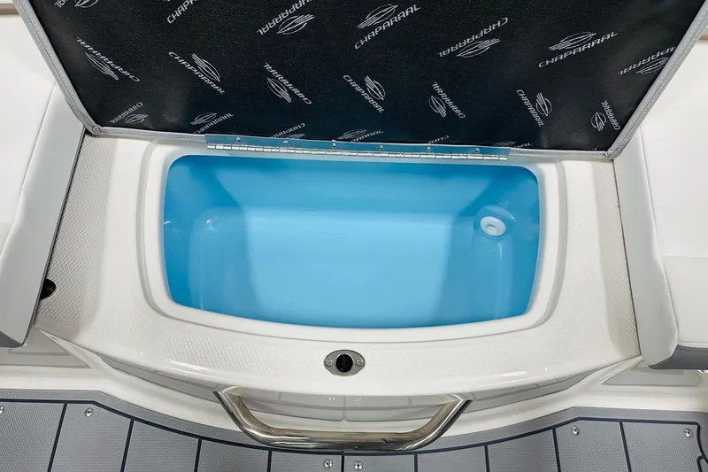 Slide: The Image of 2026 Chaparral 19 SSi OB boat storage compartment with open lid, showcasing interior. - 10