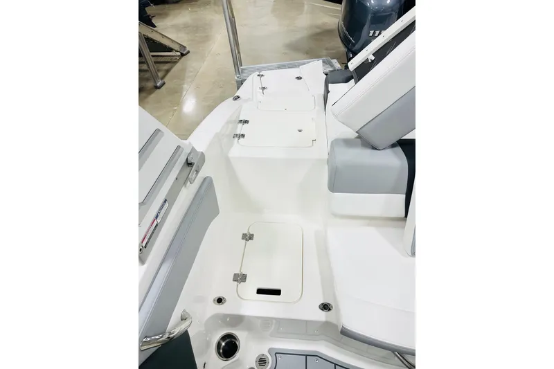 Slide: The Image of 2026 Chaparral 19 SSi OB boat interior with white and gray seating and storage compartments. - 12