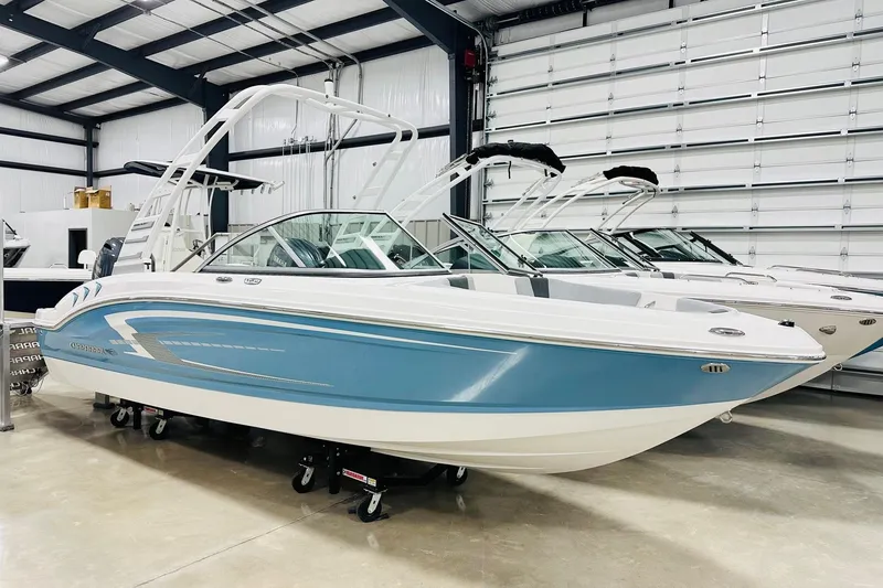 The Image of 2026 Chaparral 19 SSi OB boat in showroom, featuring sleek blue and white design. - 3