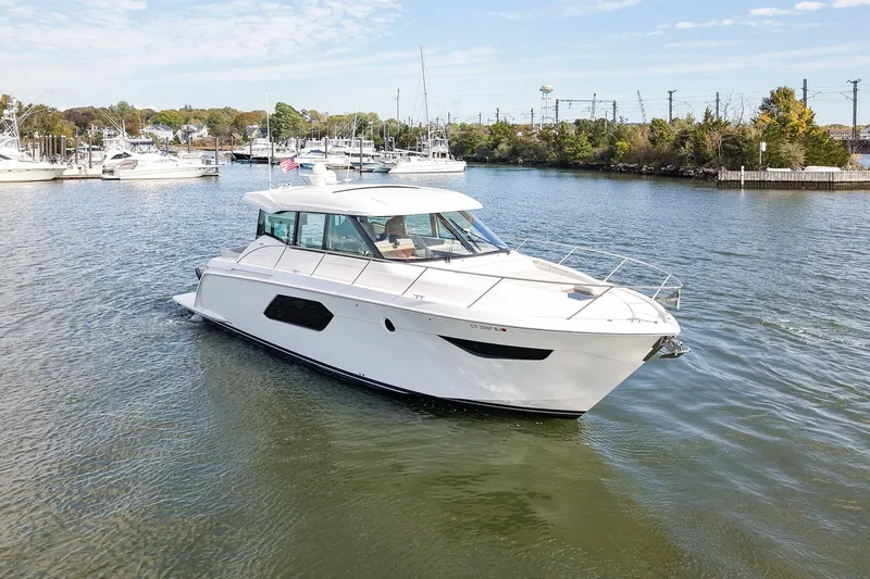 Slide: The Image of 2019 Tiara Yachts C49 Coupe cruising in a scenic marina setting. - 1