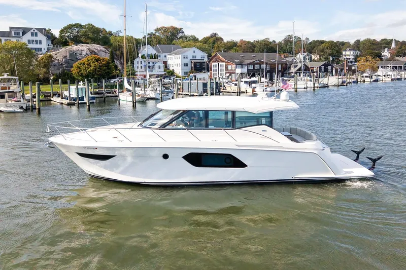 Slide: The Image of 2019 Tiara Yachts C49 Coupe cruising in a scenic marina setting. - 12