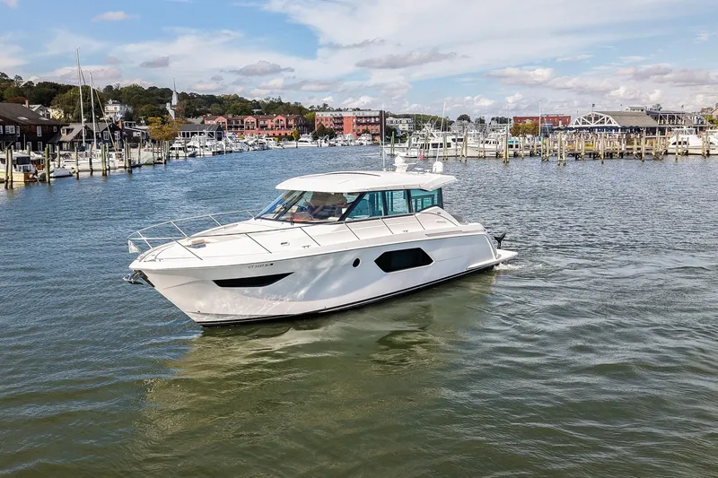 Slide: The Image of 2019 Tiara Yachts C49 Coupe cruising in a scenic marina setting. - 13