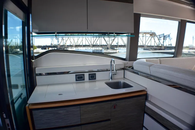 Slide: The Image of Modern kitchen area inside 2019 Tiara Yachts C49 Coupe with scenic window view. - 29