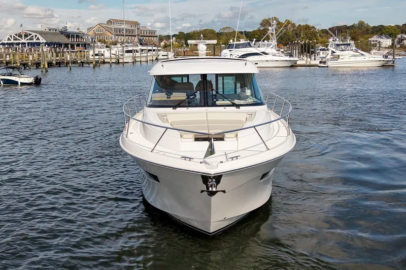 Slide: The Image of 2019 Tiara Yachts C49 Coupe in marina, surrounded by other boats and waterfront buildings. - 6