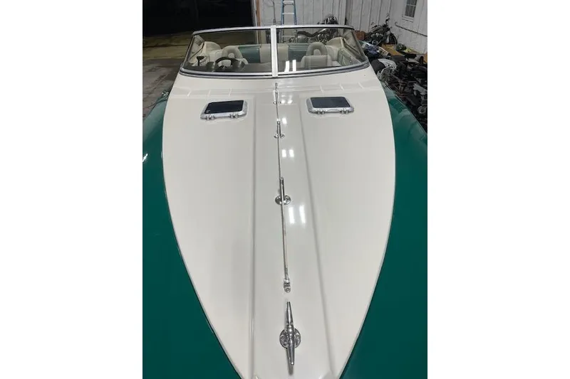 Slide: The Image of 1987 Searay Pachanga boat with sleek white and green design in a garage setting. - 2