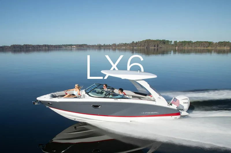 Slide: The Image of 2023 Regal LX6 boat cruising on a calm lake with passengers enjoying the ride. - 1